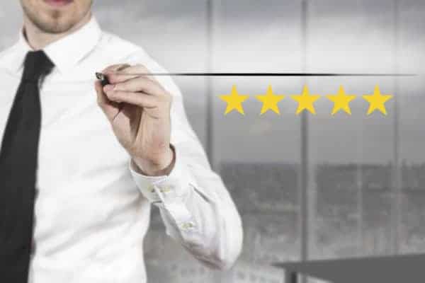 businessman in office writing five golden stars premium